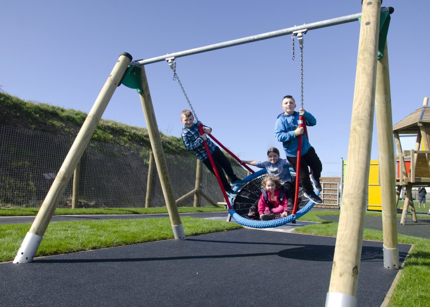 Children playing on inclusive playground equipment