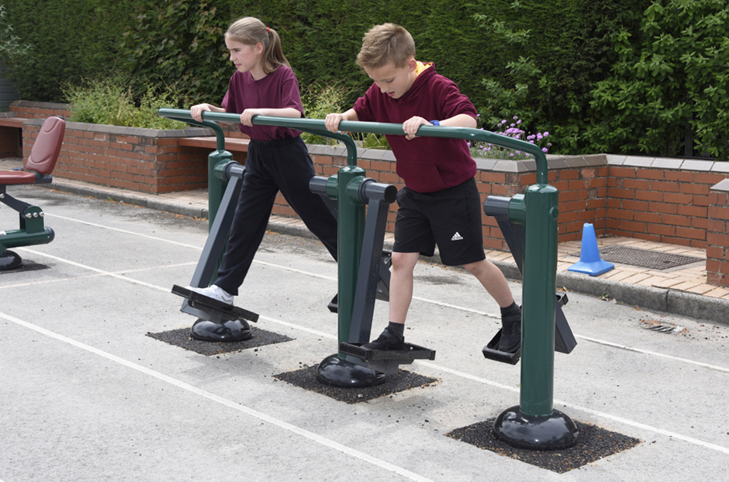 Two young children use the walking motion to use the double heath walker