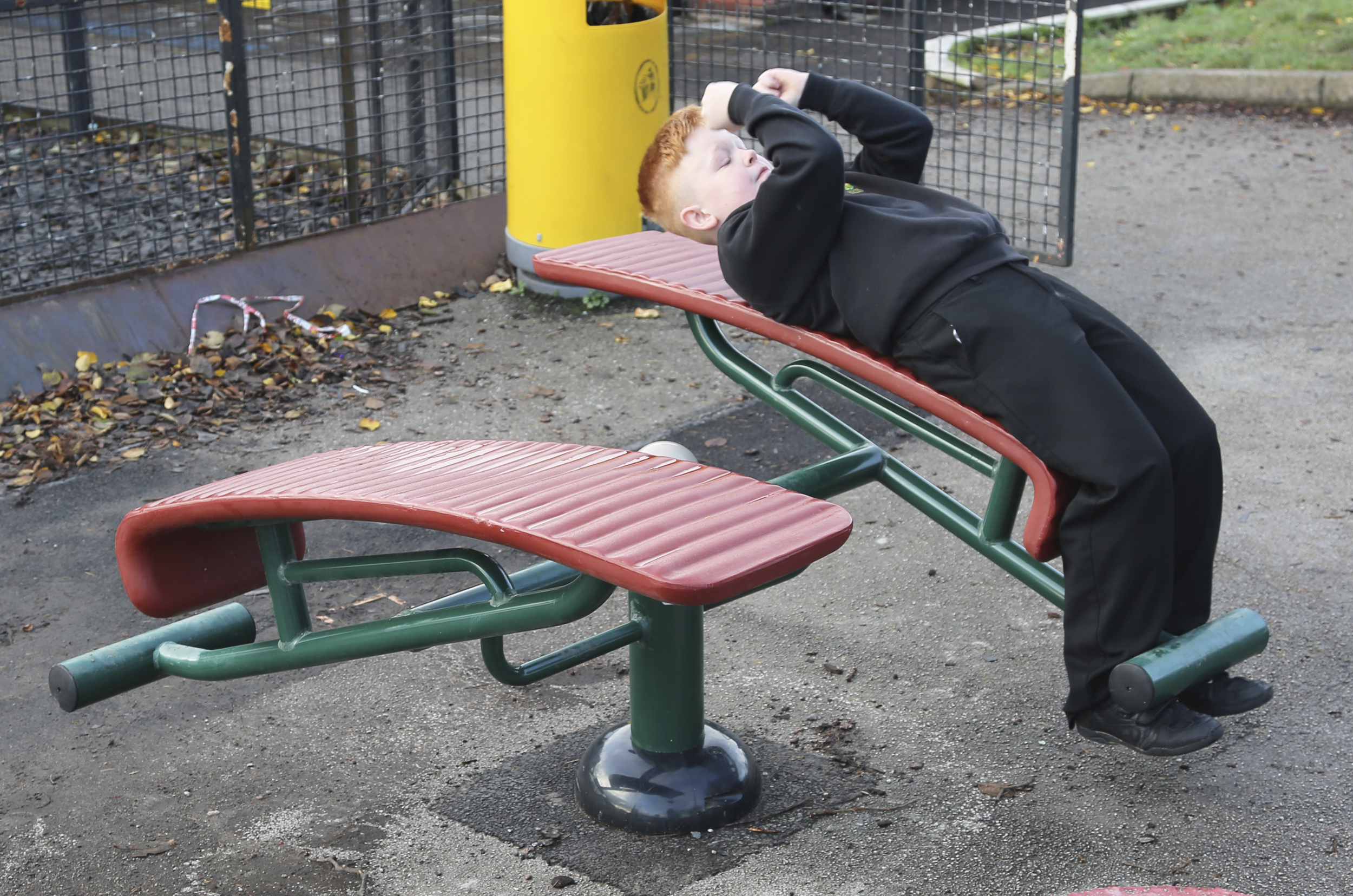 a young boy dose a sit up on one side of the sit up bench