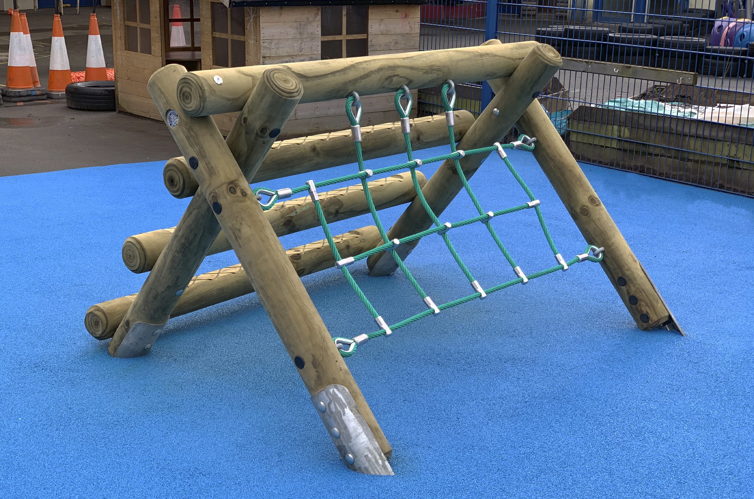 the A Frame Mini is a timber a frame with horizontal logs on the left and a green net on the right side