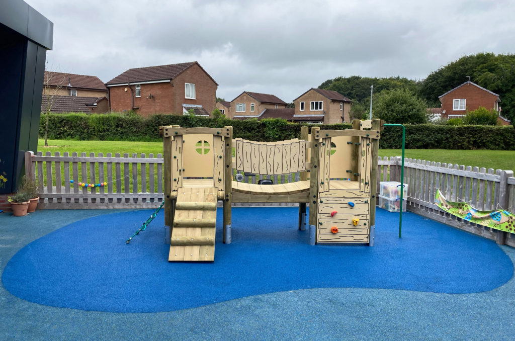 Ladygrove School - Timber climbing frame sits on blue wetpour safer surfacing