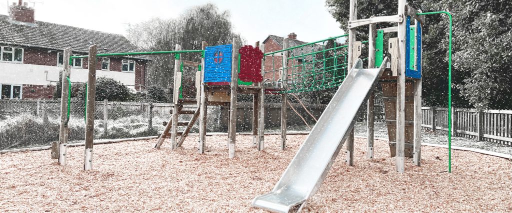 A large climbing frame with coloured panels sits in the snow